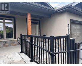 A black metal fence in front of a house with a garage door.