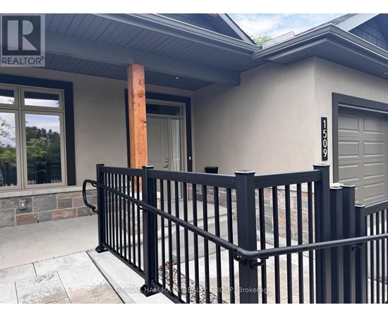 A black metal fence in front of a house with a garage door.