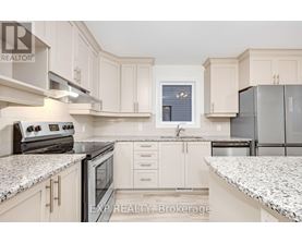 A kitchen with white cabinets and granite countertops.
