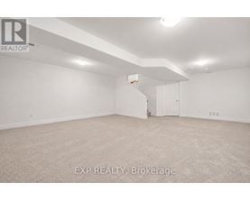 A spacious empty room with a carpeted floor and white walls.