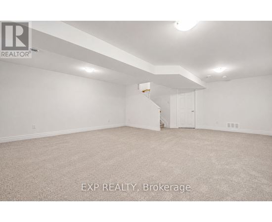 A spacious empty room with a carpeted floor and white walls.