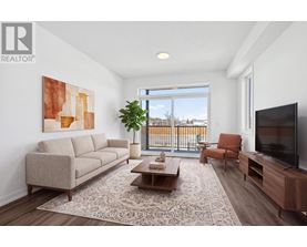 A living room with a large window, a couch, a chair, a coffee table, and a television.
