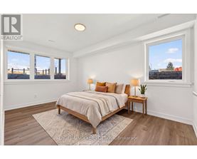 A bedroom with a bed, nightstand, and window.