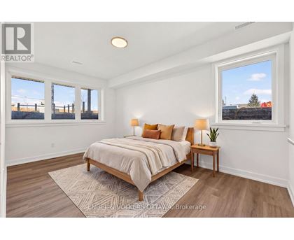 A bedroom with a bed, nightstand, and window.