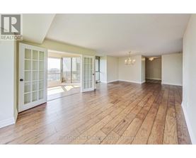 A spacious room with wooden flooring and white walls.