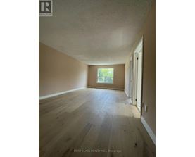 A room with wooden flooring and a window letting in natural light.