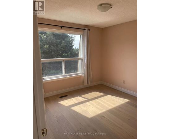 A room with a large window and wooden flooring.
