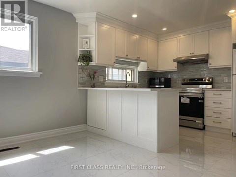 A kitchen with white cabinets and a marble floor.