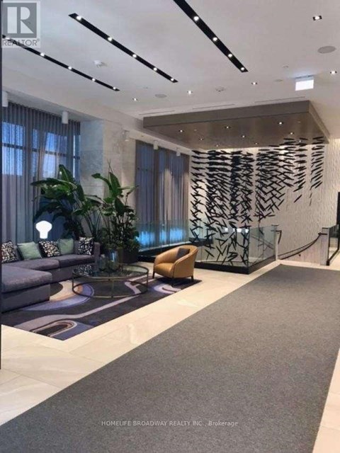 A modern living room with a grey carpet and a large abstract art piece on the wall.