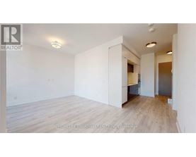 A spacious room with wooden flooring and white walls, likely for sale.