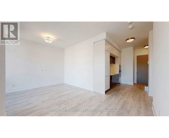 A spacious room with wooden flooring and white walls, likely for sale.