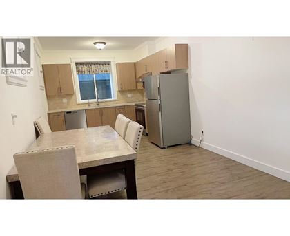 A kitchen with a table and chairs and a refrigerator.