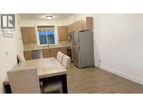A kitchen with a table and chairs and a refrigerator.
