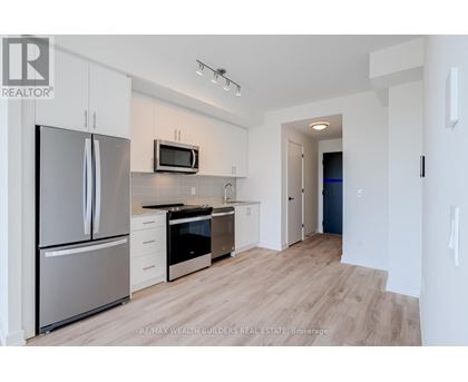 A modern kitchen with white cabinets and stainless steel appliances.