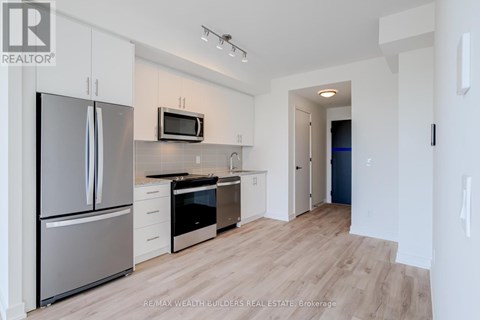 A modern kitchen with white cabinets and stainless steel appliances.