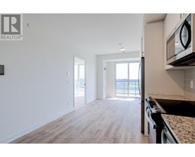 A kitchen with a granite countertop and a microwave above it.