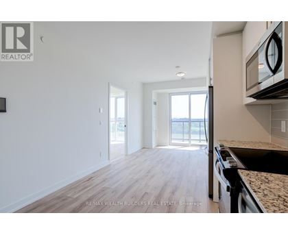 A kitchen with a granite countertop and a microwave above it.