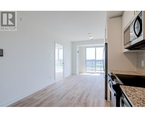 A kitchen with a granite countertop and a microwave above it.