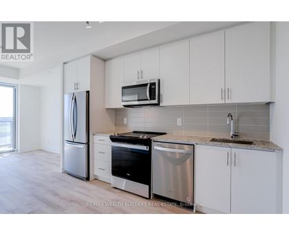 A kitchen with white cabinets and stainless steel appliances.