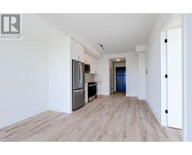 A spacious, empty room with a wooden floor and white walls.