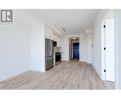 A spacious, empty room with a wooden floor and white walls.