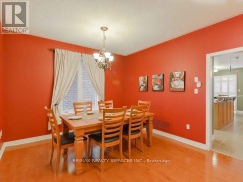 A dining room with a wooden table and chairs.