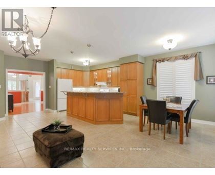 A large open kitchen and dining room with wooden cabinets and a center island.