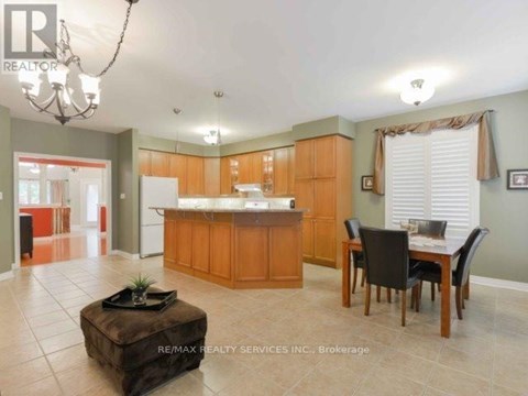 A large open kitchen and dining room with wooden cabinets and a center island.