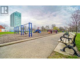 A park with a playground and a tall building in the background.