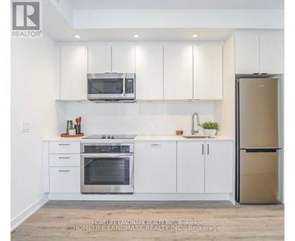 A modern kitchen with white cabinets and stainless steel appliances.