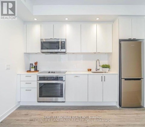 A modern kitchen with white cabinets and stainless steel appliances.
