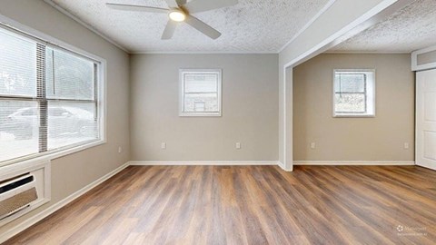 A room with wooden floors and a ceiling fan.
