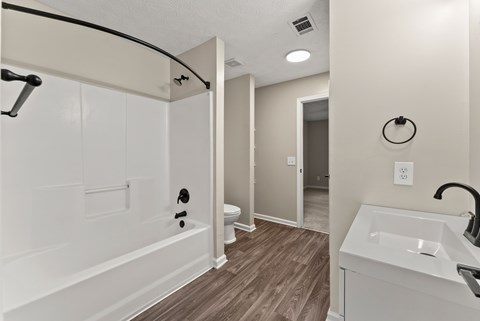 A bathroom with a white sink and a white toilet.