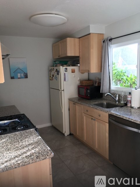 A kitchen with a granite countertop and wooden cabinets.