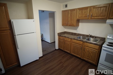 A kitchen with wooden cabinets and a white refrigerator.