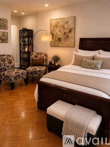 A bedroom with a large bed and a chair with a floral pattern.