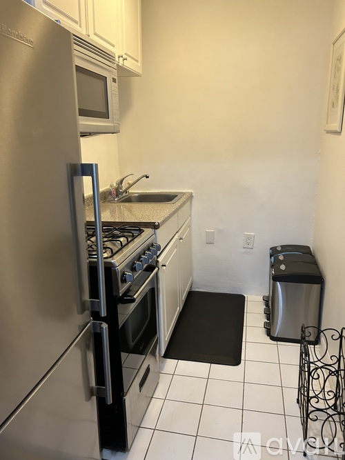 A kitchen with a stainless steel refrigerator, stove, and oven.