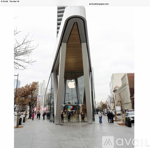 A modern building with a curved facade and an Apple store in the front.