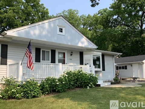 A house with a flag on the porch and a white picket fence.