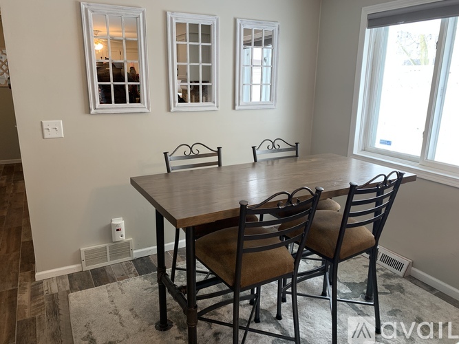 A dining room with a table and chairs.