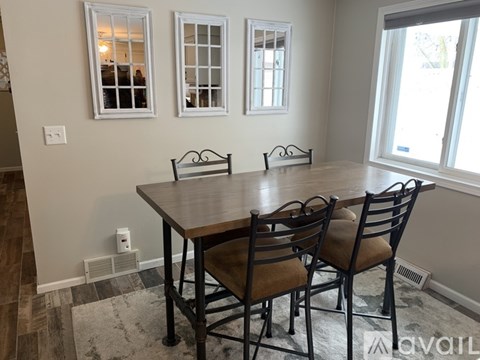 A dining room with a table and chairs.