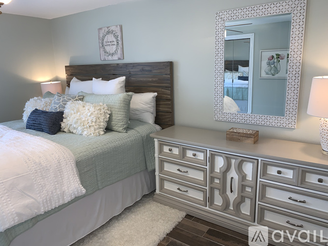 A bedroom with a bed, dresser, and mirror.