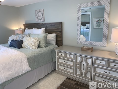 A bedroom with a bed, dresser, and mirror.