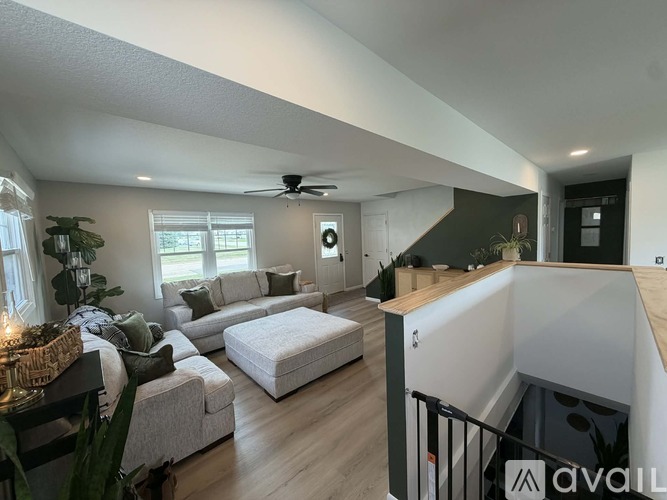A living room with a white couch and a ceiling fan.