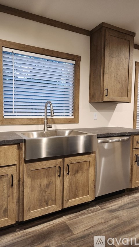 A kitchen with wooden cabinets and a stainless steel sink.