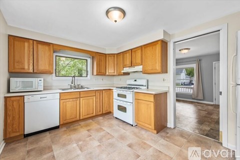 A kitchen with wooden cabinets and white appliances.