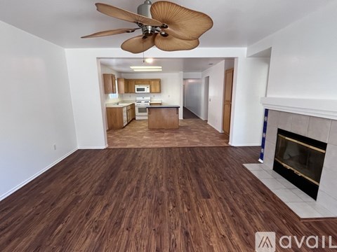 A living room with a fireplace and a ceiling fan.
