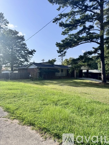 A house with a yard and a tree in front.