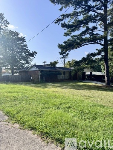 A house with a yard and a tree in front.