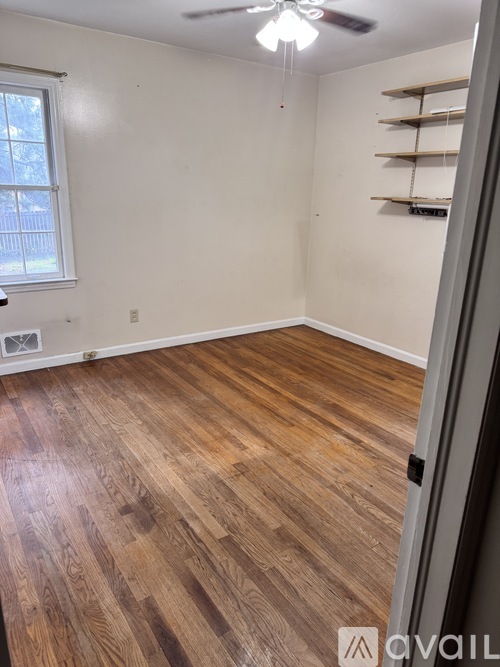 A room with wooden flooring and a ceiling fan.